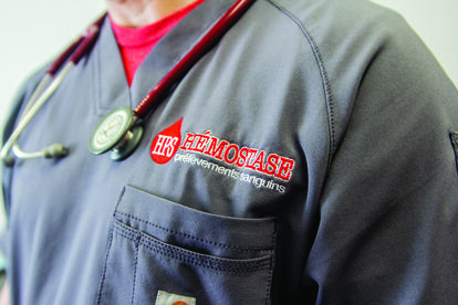 Embroidered Hemostasis logo on the blouse.